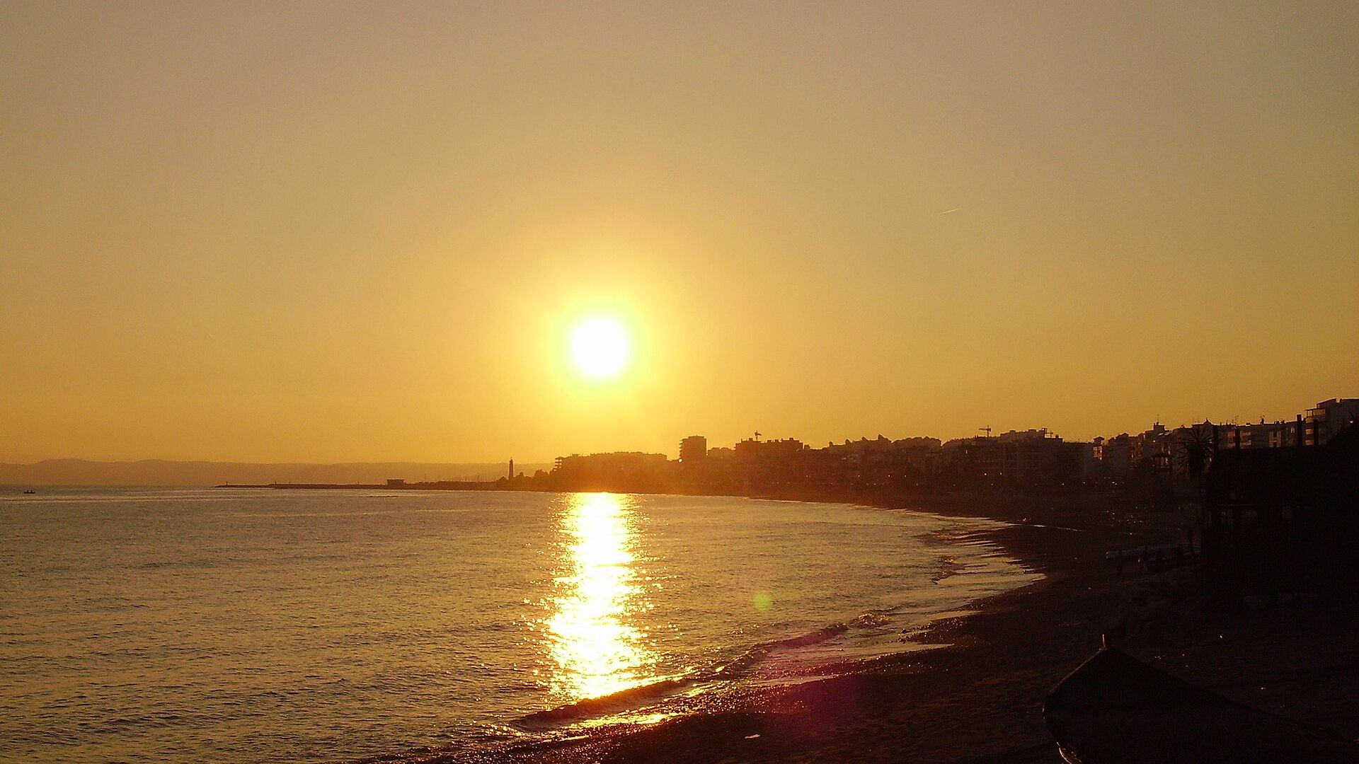 The sun setting over the sea at Estepona, the light running up the beach